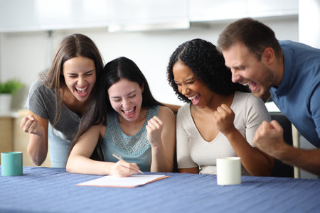 Excited roommates signing lease contract in the kitchen at homeの写真素材