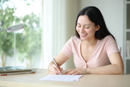 Happy asian woman signing paper contract in a room at homeの写真素材