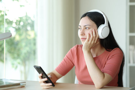 Asian woman wearing headphone listening music in a roomの写真素材