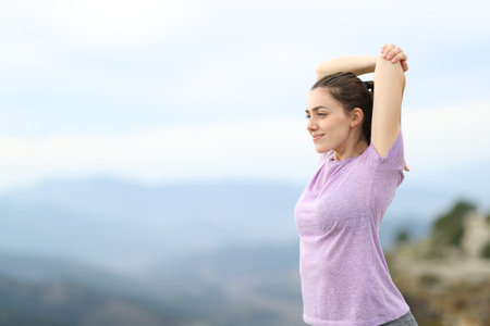 Runner or yogi stretching arms after sport standing in natureの写真素材