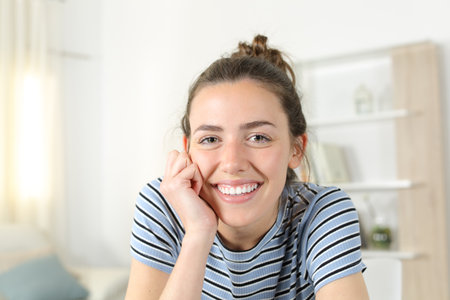 Front view portrait of a happy woman with perfect teeth smiling at you at homeの写真素材