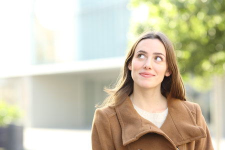 Beautiful woman in winter looking at side in the streetの写真素材