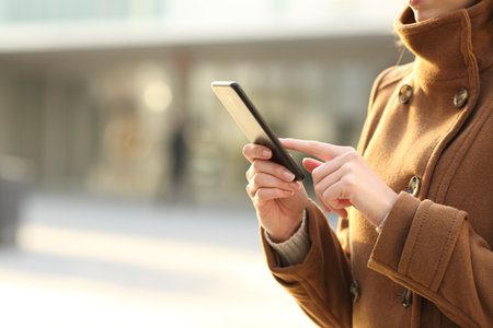 Close up of a woman hand using smartphone in winter on the streetの写真素材