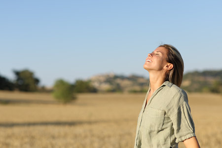Happy ecotourist breathing fresh air in a wheat field in a rural environmentの写真素材