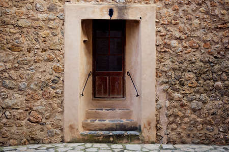 traditional old door and wall in the historic village Deia in Majorca, creative editing to give the ancient aspectの写真素材