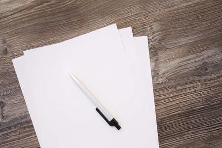 paper and pencil on wooden table,selective focus