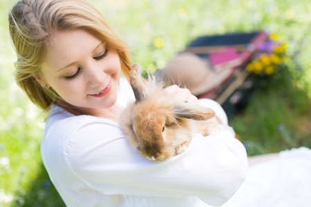 Teenager girl with bunny in the nature, selective focus and creative vintage editing with slightly noiseの写真素材