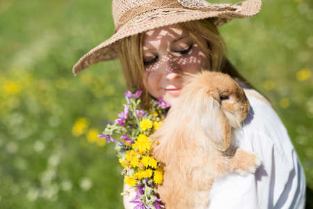 summer girl with bunny in the nature, selective focus on the bunnyの写真素材