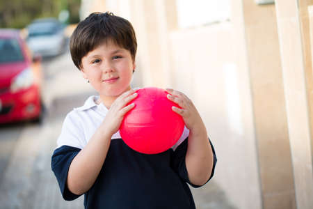 Little boy with pink ball in the street,selective focusの写真素材