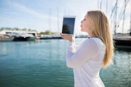 Kissing teenager with digital tablet outdoor,selective focusの写真素材