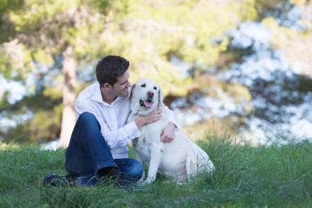 young men with his old labrador dog in the park