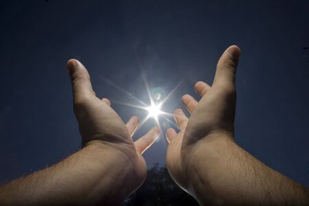 human hand, sun and blue skyの写真素材