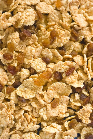 bowl of cereal with raisins, milk and orange juice