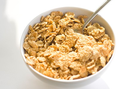 bowl of cereal with raisins, milk and orange juice