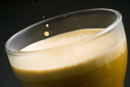 Espresso coffee cup with cream isolated on black