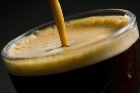 Espresso coffee cup with cream isolated on black