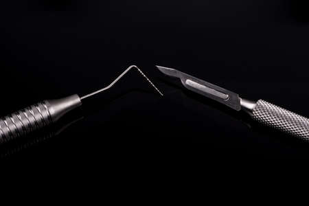 Horizontal color image with a front view of a professional dental tools on a black background....