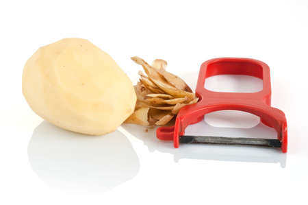 plastic potato pealer with peeled potatoes isolated on white backgroundの写真素材