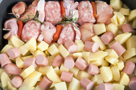 detail of raw pork kebab with sliced potatoes, wurstel and rosemaryの写真素材