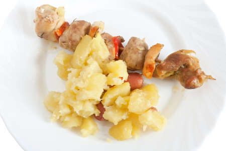 detail of baked pork kebab with potatoes on a dishの写真素材