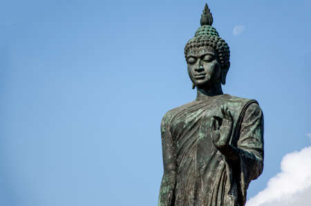 Buddha statue standing on the left hand with blue sky background,Buddha statue Thailandの写真素材