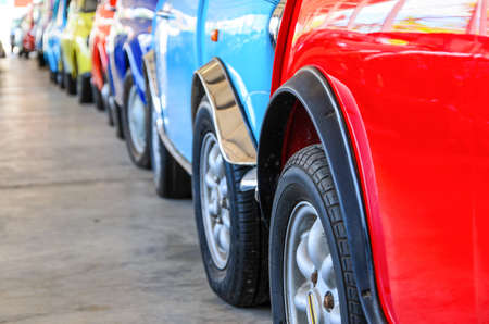 Colorful cars standing in line on parking cars, different colored cars of sideviewの写真素材