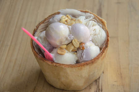 Coconut ice cream with pink spoon on wooden backgroundの写真素材
