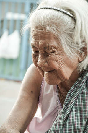 Samutsakorn,Thailand-12 May: Unidentified Thai old woman the face is full of wrinkles. But the expression is happy with some of the work being done,on May 12,2013 in Samutsakorn Thailand.のeditorial素材