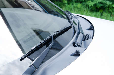 Section of the front of a white vehicle and its front windscreen bonnet and wipers.の写真素材