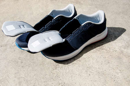 Sports blue shoes were put to dry on the cement floor after washing.の写真素材