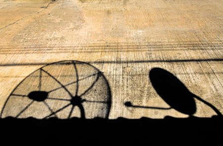 Shadow from the satellite dish on the roof of the house shines on the cement road.の写真素材