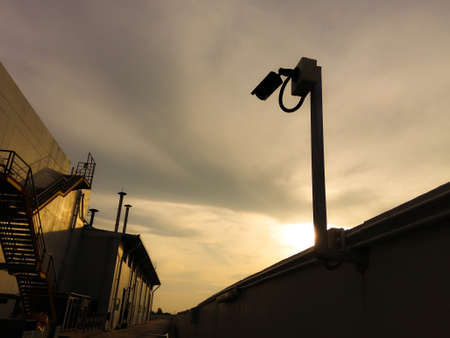 Security camera on the fence wall in the surveillance of industrial facilities.の写真素材