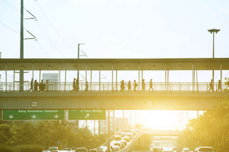 People walk on bridges with cars on the road.の写真素材