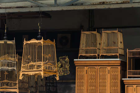 Bird cages are made of wood, hung for sale to interested customers.