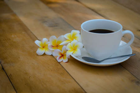 flowers with black coffee on wooden background, Take a break with hot coffee on nature background in...