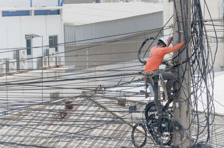 Technician is repairing the telephone line system on the power poles.のeditorial素材
