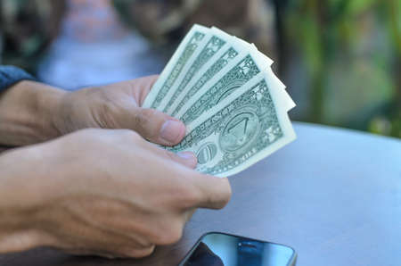 Businessman hand holding dollar banknotes in officeの写真素材