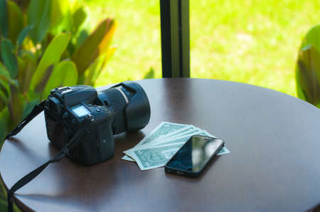 Camera, mobile phone and banknotes are placed on the table, the concept of tourism, Travel plan, trip vacation,の写真素材
