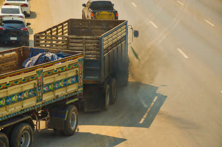 Truck emits black smoke while running on the road.の写真素材