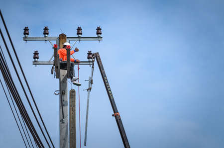 Electricians are climbing on electric poles to install and repair power lines.