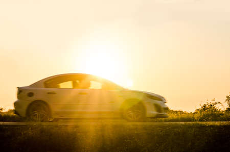 blurry image of car on the road travel holiday summer go relax  with sunset background.の写真素材