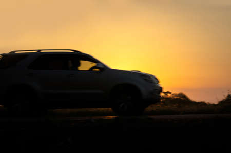 blurry image of car on the road travel holiday summer go relax  with sunset background.