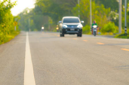 Blurred back side of car running on the asphalt road, Focus on roadの写真素材