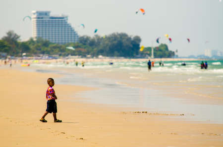 Prachuap Khiri Khan, Thailand - April 2019:  Unidentified Thai boy walking on Hua Hin beach in summer, April 14, 2019, in Prachuap Khiri Khan, Thailandのeditorial素材