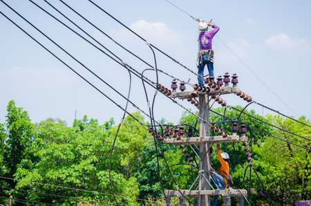 Samut Sakhon, Thailand - May 2019: Electricians are climbing on electric poles to install and repair power lines.on 19 May 2019 in Samut Sakhon, Thailand.のeditorial素材