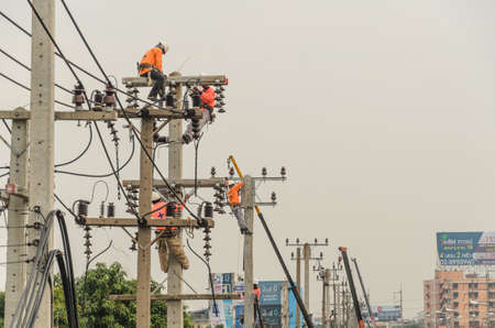 Samut Sakhon, Thailand - December 2018: Electricians are climbing on electric poles to install and repair power lines.on 9 December 2018 in Samut Sakhon, Thailand.のeditorial素材
