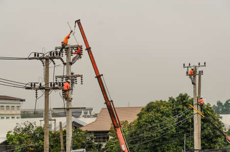 Samut Sakhon, Thailand - December 2018: Electricians are climbing on electric poles to install and repair power lines.on 9 December 2018 in Samut Sakhon, Thailand.のeditorial素材