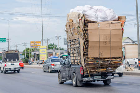 Samut Sakhon, Thailand - July 2019: Small trucks carrying recycled paper boxes on Phutthasakorn Road on July 28, 2019 in Samut Sakhon, Thailand.のeditorial素材
