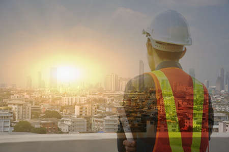 Engineer close-up photos and looking at the city, double exposure, big city view, wide sunset...