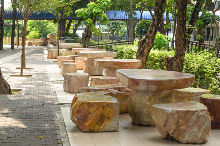 Stone tables and chairs in the shady gardenの写真素材